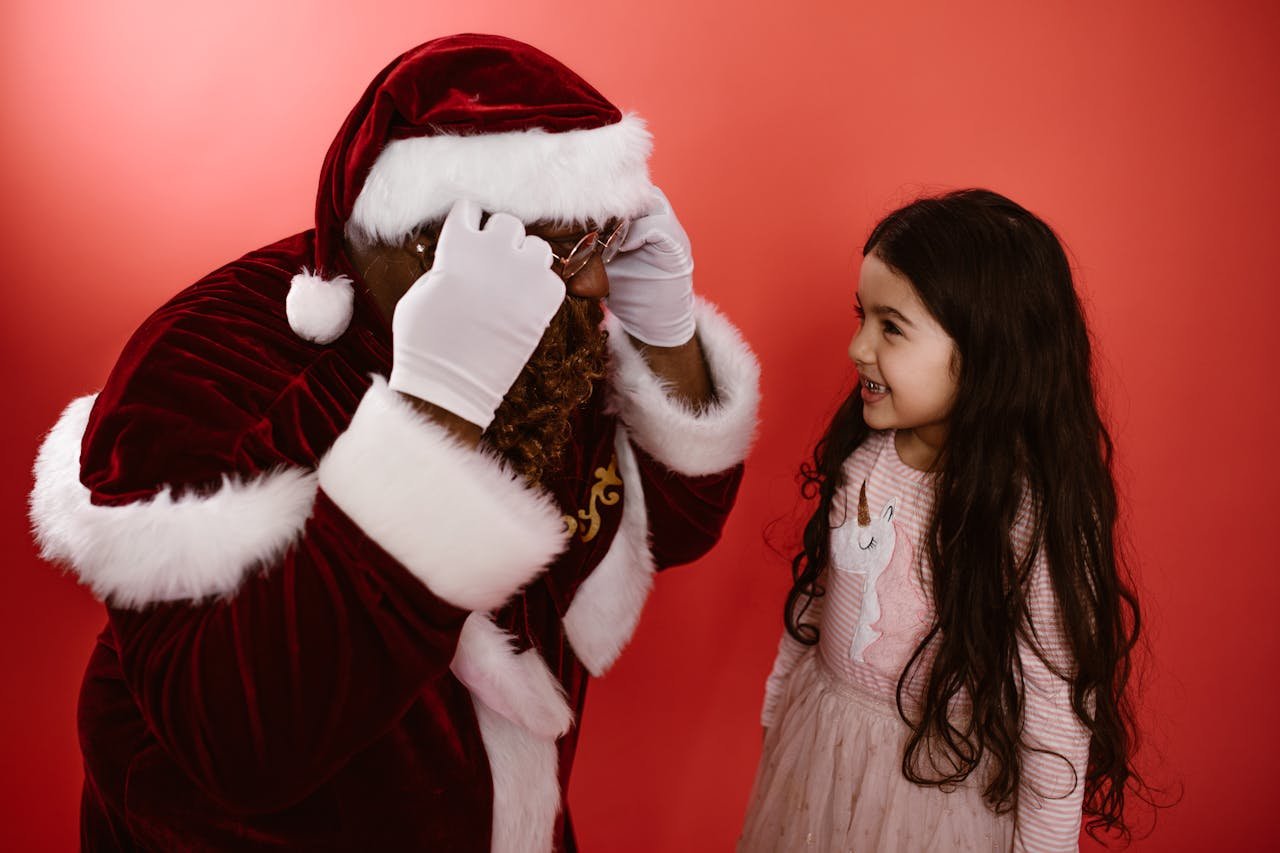 Smiling child with Santa Claus in festive setting, capturing Christmas joy.